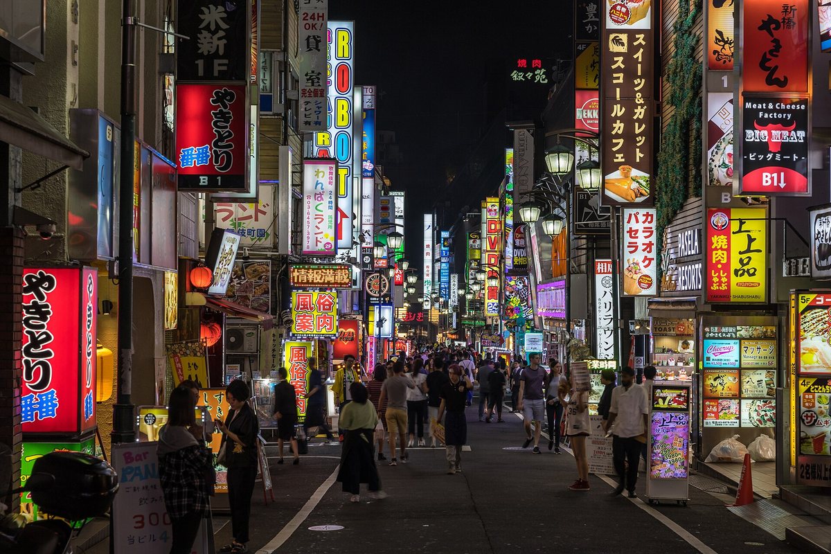Neon signs illuminate a busy street in Kabukicho, Tokyo