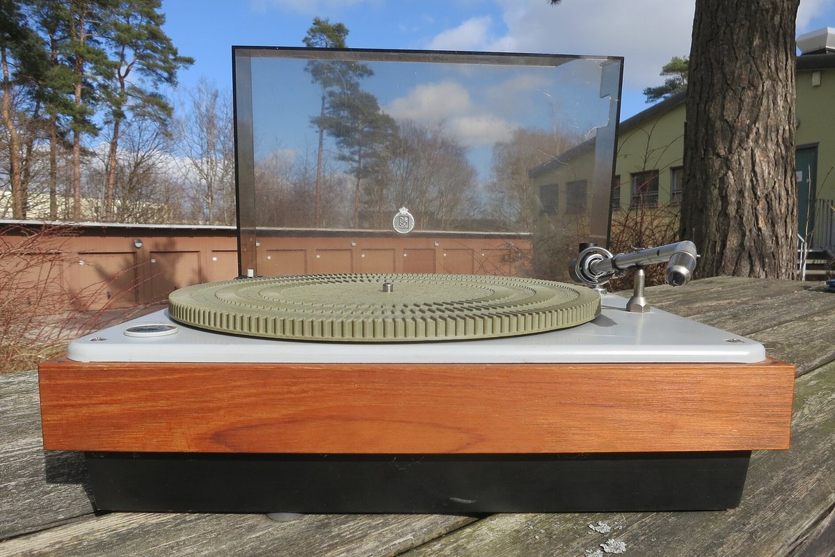 A vintage Bang & Olufsen turntable with its clear lid open