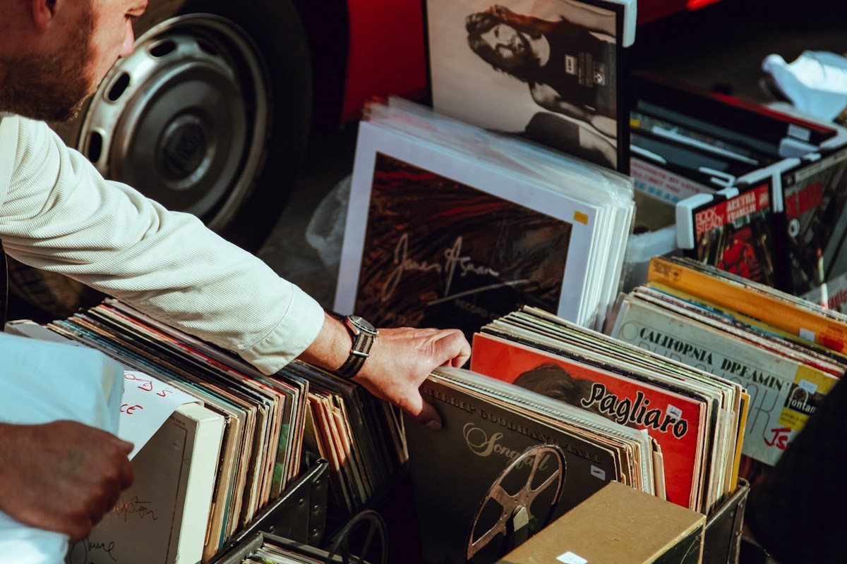 A shopper lifts an album from a bin of vinyl records