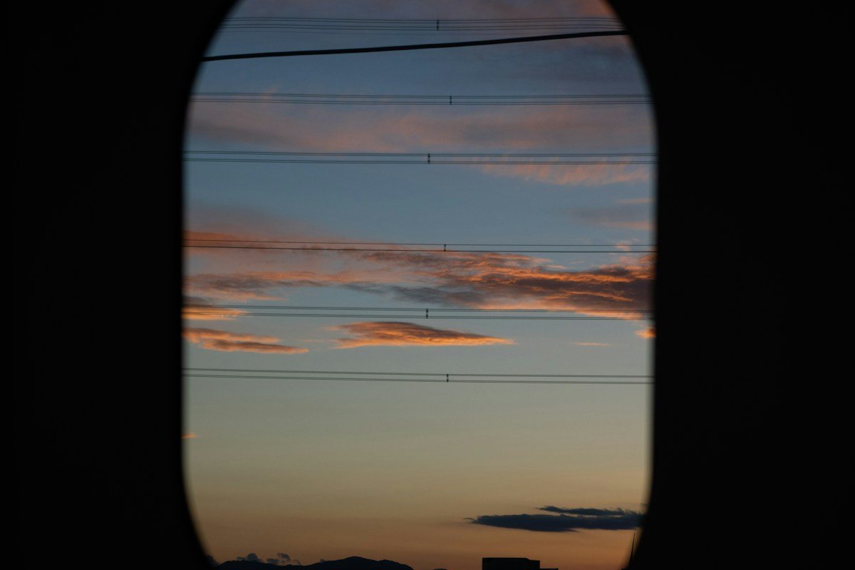 Sunset clouds seen through the rounded window of an airplane