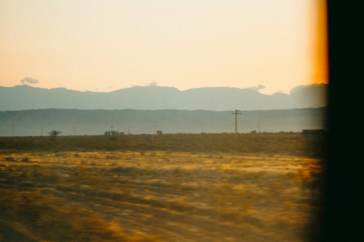 Golden fields and distant mountains viewed through a window