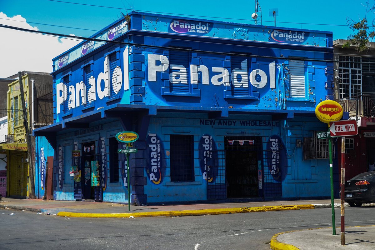 A brightly painted blue corner building in downtown Kingston, Jamaica
